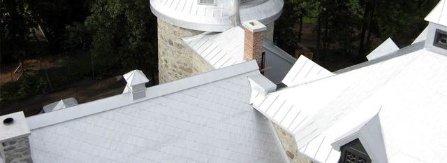 Toiture à pincette blanche sur chapelle de campagne avec tour en pierre — vue aérienne
